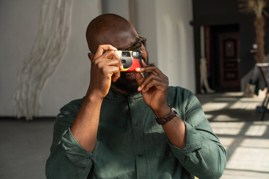 Man Using Disposable Camera in Sunlit Studio 