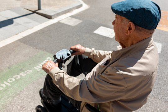 Senior Man on mobility Scooter on city. 