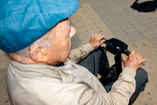Elderly Man Riding Electric Scooter on City Street
