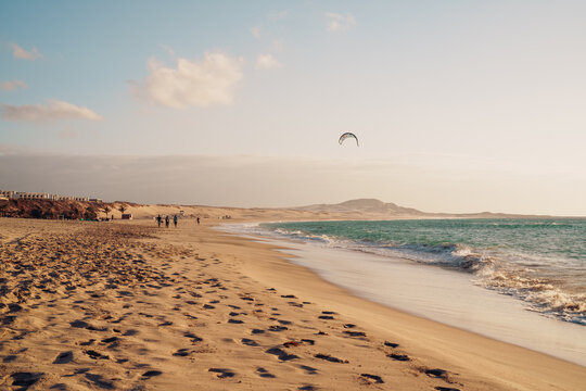 Ocean coastline at golden hour with windsurfer silhouette at Chaves Beach, Cape Verde