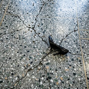 Top-down hotel lobby terrazzo floor fracture seismic chips popping high-heel shoe sliding earthquake