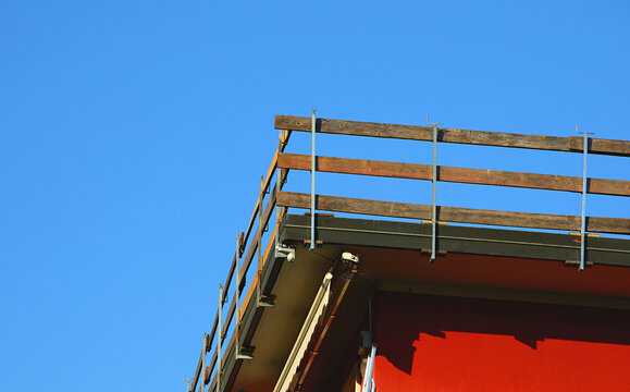 Parapet with sturdy wooden planks to prevent falls installed on the roof of the house