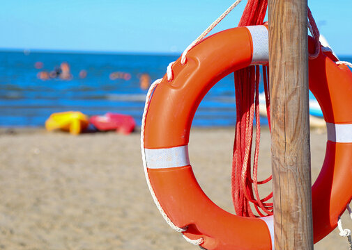 lifebuoy on the sandy beach in summer with the sea in the background
