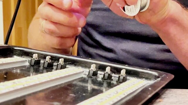 Hands skillfully solder and drill electronic components on a workspace, with smoke rising gently. A cozy atmosphere indoors invites creativity and learning.