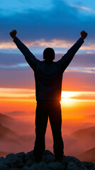 Fototapeta premium Silhouette of a successful person raising arms in triumph on a mountain peak at sunrise symbolizing achievement and motivation.