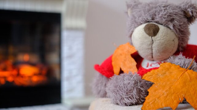 Plush teddy bear  by the fireplace, cozy living room, soft blanket is draped over the armchair, quietly enjoying the serene atmosphere. Happy time at the home.