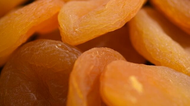 Dried apricots background close-up. Apricot fruits. Ripe Organic Apricots fruit rotating backdrop. Close up. Heap of dried apricot background, vegan food, top view. 