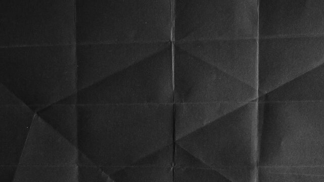 Abstract black paper texture with geometric fold lines and creases
