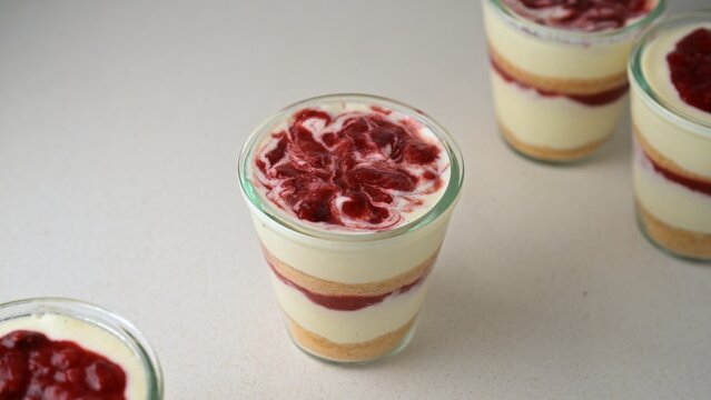 Homemade cottage cheese (farmers cheese) dessert cups layered with vanilla cookie crumbs and strawberry confit sauce. Creamy no-bake cheesecake inspired dessert with berry swirl topping. Soft