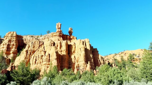 A smooth first-person POV video driving through Dixie National Forest, Utah during a golden hour sunset. Scenic view of pine trees, red rocks, and crimson soil. Authentic American road trip vibe.