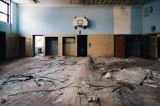 Abandoned classroom with broken floor and damaged walls