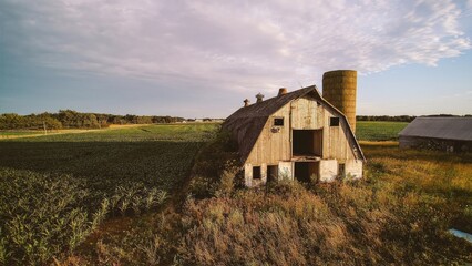 Old barn with silo in the countryside during sunset © Roxana