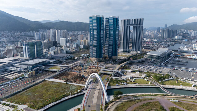 Aerial view of modern skyscrapers and the North Port redevelopment area featuring a bridge, harbor facilities, and construction sites in Busan, Busan, South Korea.