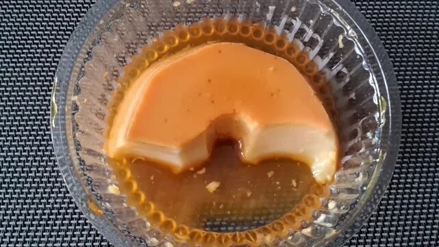 Sweet caramel custard pudding dessert in glass bowl motion video footage