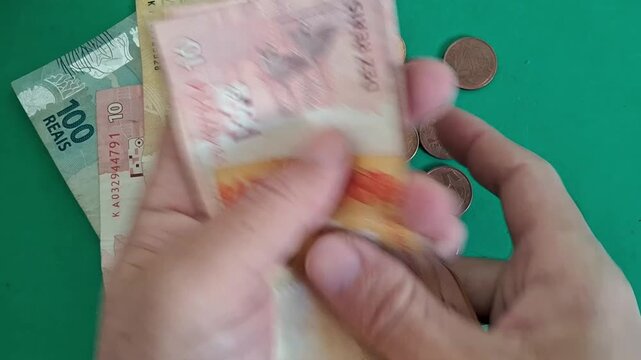 Hands counting Brazilian real banknotes in motion video clip sequence