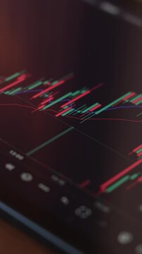 CloseUp of Trader Analysing Stock Market Charts on an iPad Through a Brokerage Platform