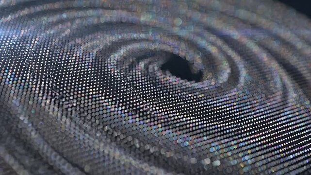 A close-up abstract view of a textured surface with shimmering holographic dots in a spiral pattern.