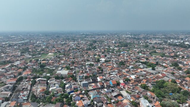 Aerial view of the dense urban landscape of Serang with terracotta rooftops, narrow streets, and residential buildings in Kecamatan Serang, Banten, Indonesia.