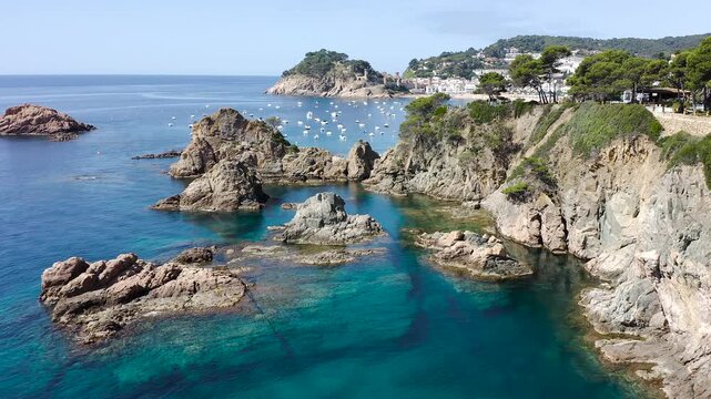 Aerial view of the rugged cliffs surrounding Tossa de Mar, where rocky reefs, hidden coves and crystal-clear Mediterranean waters create a spectacular coastal landscape. 