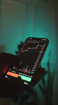 Trader Analyzing Stock Market Charts on Smartphone Through Brokerage App