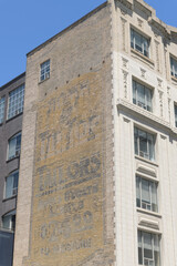 Fototapeta premium historic ghost sign on the west facing exterior of 260 Richmond St W, originally used as a Tip Top Tailors warehouse (built 1914, expanded 1924), Toronto