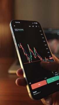 Trader Analyzing Stock Market Charts on Smartphone Through Brokerage App
