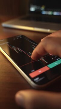 Trader Analyzing Stock Market Charts on Smartphone Through Brokerage App
