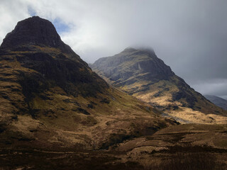 Obraz premium A view of Three Sisters Mountain along the Lost Valley trail in the highlands of Glencoe, Scotland