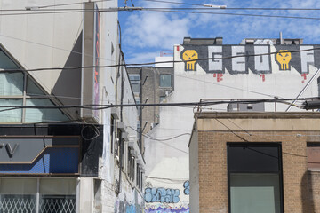 Naklejka premium looking north on Dundas St W, west of Spadina Av, to buildings incl (left) K-ONE KTV, (right) Scotiabank, and graffiti on the exterior of 310 Spadina Av, Toronto