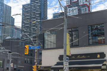 Naklejka premium buildings and sign outside Aux Merveilleux de Fred, a pastry shop located at northwest corner of McCaul & 224 Queen St W, Toronto