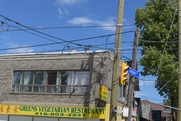 Naklejka premium exterior of old building and sign of Greens Vegetarian Restaurant, a vegan restaurant, located at 638 Dundas St W, Toronto