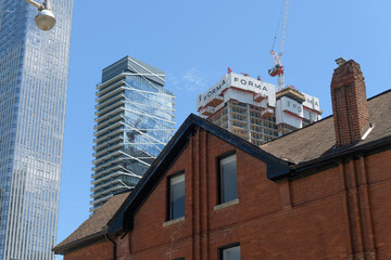 Naklejka premium detail of old house at 129 John St with view of Thomson Reuters building, Theatre Park apartment, and construction of Forma Condos, Toronto