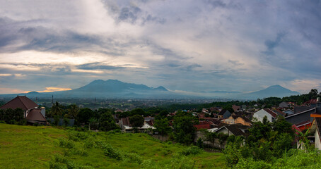 Fototapeta premium Beautiful twilight over Malang city valley with Mount Kawi and Mount Arjuno views at sunset, East Java, Indonesia