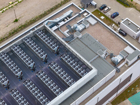 Aerial view of an advanced AI data center roof featuring rows of industrial cooling fans and ventilation systems in Warsaw, Masovian Voivodeship, Poland.