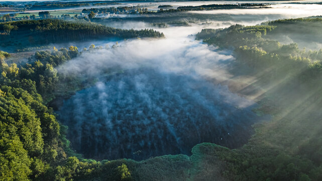 Mist over lake at sunrise in autumn.