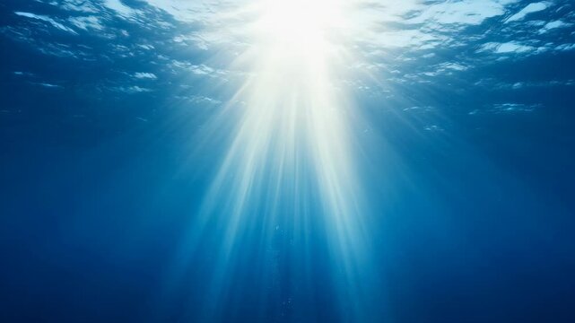 Sunlight pierces deep ocean, creating dramatic beams. Water clarity reveals serene underwater world