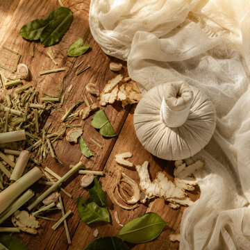 Traditional Thai Luk Pra Kob Herbal Compress Flat Lay with Natural Botanicals.