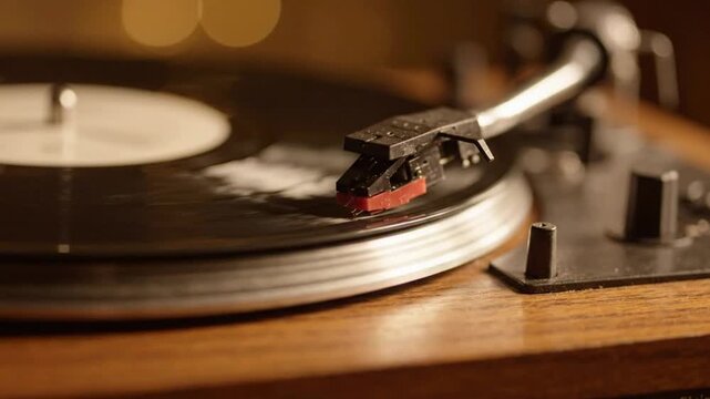 Vintage vinyl record player spinning with warm golden bokeh lighting, close-up analog music experience