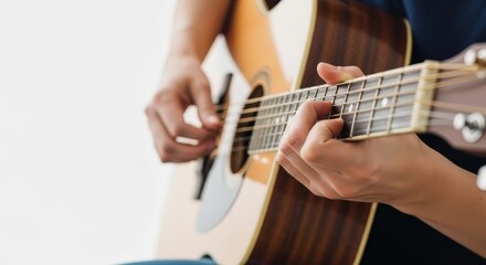 Obraz premium Close up of hands playing an acoustic guitar. Musician pressing strings on the fretboard against a white background