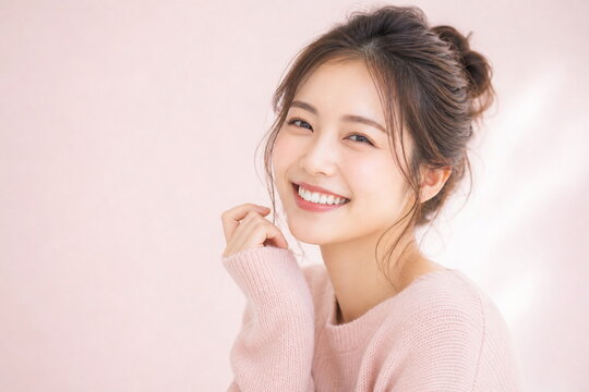 ピンクニットのおだんご髪女性の明るい美容ポートレート
