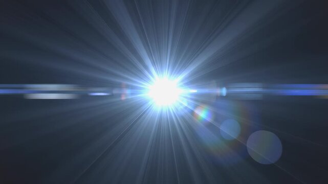 Bright white optical lens flare expanding and glowing intensely against dark background, concept of cinematic lighting effect