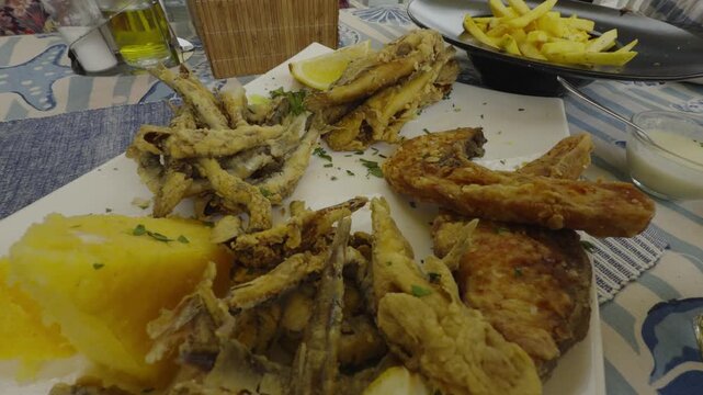 Crispy Deep Fried Small Anchovy Fish With Fresh Lemon Slice And Polenta. Mediterranean Seafood Appetizer Dish
