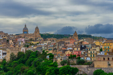 Obraz premium Ancient Sicilian city skyline with baroque cathedral spires under moody September clouds