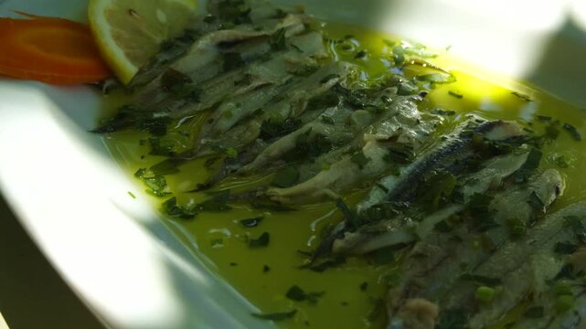 Marinated Anchovies Fish Fillets In Olive Oil With Herbs And Lemon Slice. Mediterranean Seafood Appetizer