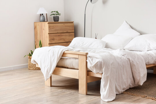 Big comfortable bed with white bedding in hotel room