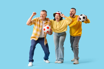 Fototapeta premium Soccer fans with balls on blue background