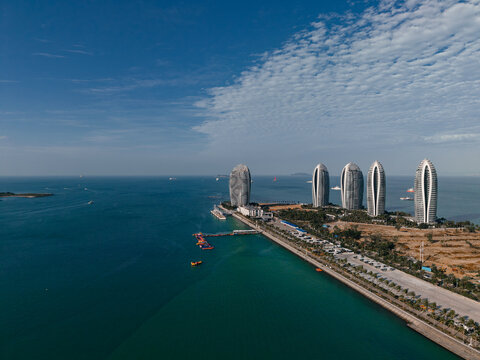 Modern curved towers overlooking turquoise bay from aerial viewpoint Sanya Hainan Island, China
