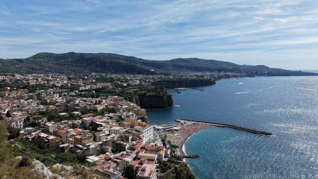 Aerial view of Meta di Sorrento coastal town with Punta Scutolo rocky promontory, tuff cliffs, and Gulf of Naples panorama, Sorrento Peninsula, Italy