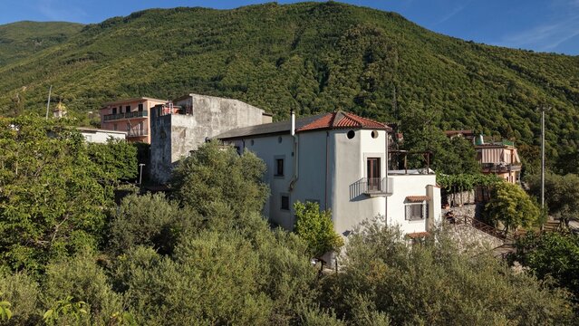 Aerial view of residential buildings in Aurano frazione with green mountain slopes and olive groves in Gragnano, Naples, Campania, Italy