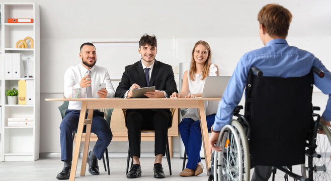 Human resources commission interviewing job applicant in wheelchair at office